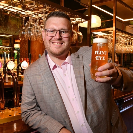 A man holding a pint of beer