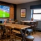 The interior restaurant seating area of The Parsonage in Leigh, with wooden tables and a TV on the wall.