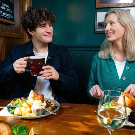 A group of friends seated in the restaurant and seating area of a Urban Social venue, enjoying Sunday roast dinners and drinks.