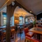 The interior restaurant seating area of The White Hart in Frimley, with wooden beams, and a TV on the wall.