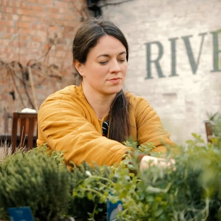 A woman tending to plants.