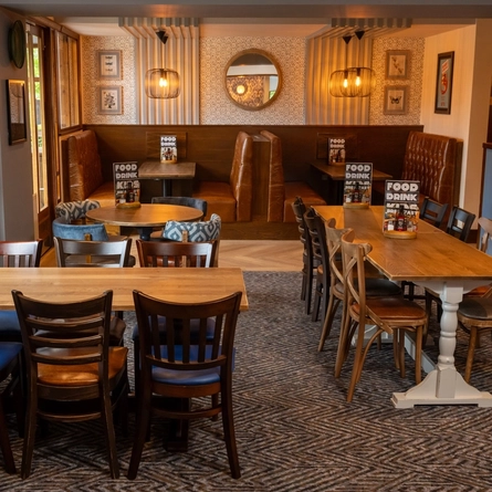 The interior restaurant seating area at The Wall's End in Wallsend, with upholstered booth seating, and framed artwork on the walls.