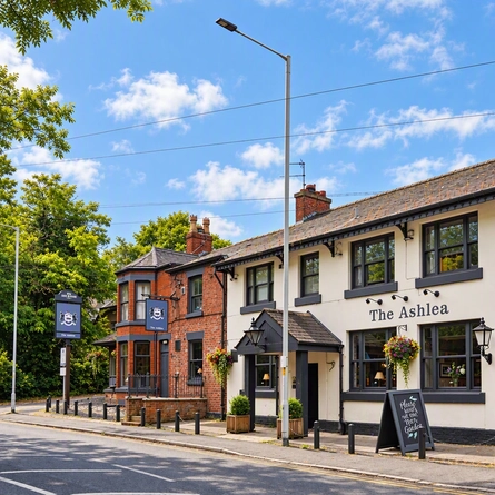 The exterior facade of the venue with venue signage, hanging baskets and lantern lighting at The Ashlea.