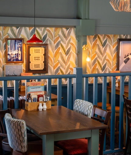 The interior restaurant seating area at The Man On The Moon, with wooden tables and upholstered seating.