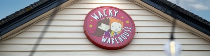 A close up view of the Wacky Warehouse sign on the exterior facade of The Vine Inn.