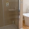 The interior hotel bathroom with a shower and bath at the Cedars Inn.