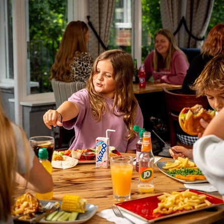 A family sat at an indoor table enjoying a meal and drinks at a Hungry Horse venue.