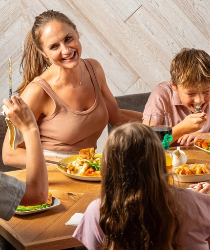 An image of a family enjoying a Sunday Roast and various drinks within the interior restaurant and seating area at a Hungry Horse venue.