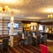 Interior dining area of a pub with a bar and a TV.