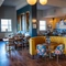 The interior restaurant seating area of The Kittoch in East Kilbride, with upholstered booth seats, and framed artwork and a TV on the wall.
