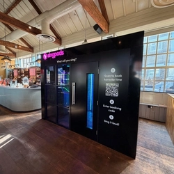 A Singpods Karaoke booth in a bar interior.