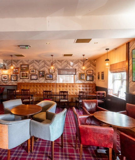 Interior dining area of a pub with a TV and a few gambling machines.