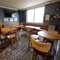 Interior dining area of a pub with a bar, a gambling machine and a TV.