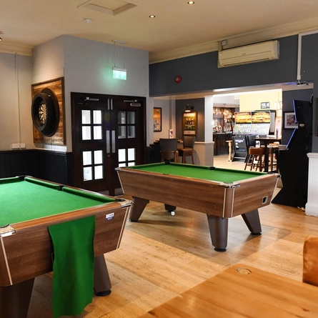 The interior games area with pool tables, a dartboard and electronic pub games area at The Bradmore Arm.