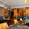 The interior restaurant seating area at The Talbot in Worcester; with upholstered chairs, benches, and booth seating; a TV on the wall; and a gaming machine.