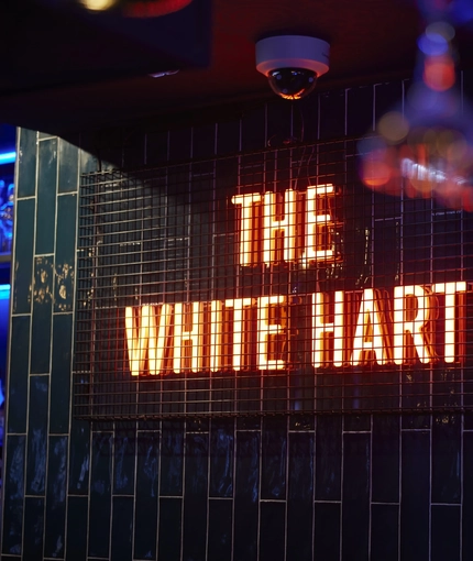 A neon sign on the wall of the White Hart.