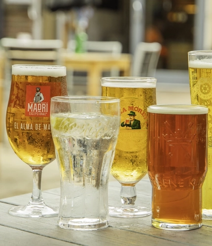 A range of lagers, ale and soft drinks on an outdoor table.
