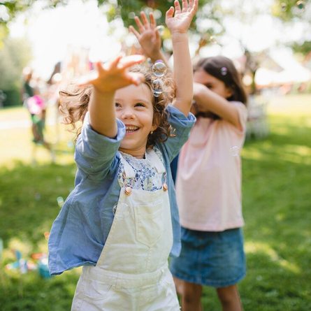 An image showing 2 children running around playing with bubbles to advertise Summer Parties at Chef & Brewer venues.