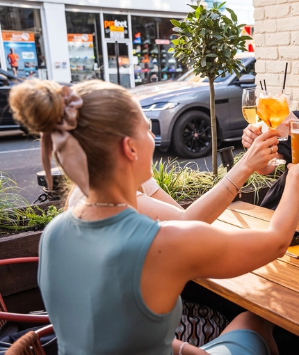 A group of people enjoying drinks within the exterior beer garden seating area during The Durell Arms launch party.