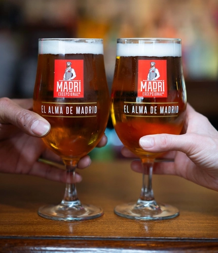 2 pints of Madri being held at the bar at Flaming Grill.