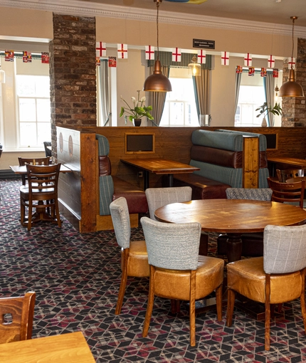 Interior dining area of a pub with TV screens.