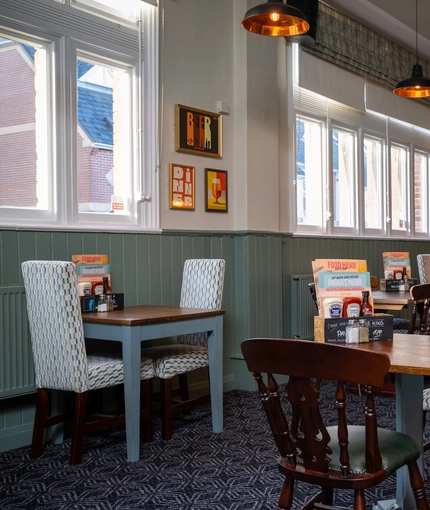 An interior restaurant seating area at the Green Posts, with a TV on the wall.