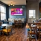 An interior restaurant seating area at The Kittoch, with an upholstered booth seat, and a TV on the wall above it.