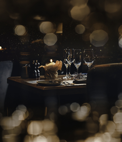 A table in a pub restaurant, with out of focus lights across the top and bottom of the picture.