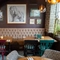 An interior restaurant booth seating area at The White Lion, with upholstered seat, and framed artwork on the wall.