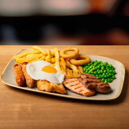 A plated Full Monty Mixed Grill on a wooden table.