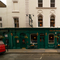 The exterior facade, signage, and seating area at The Plough in Bloomsbury, with flower baskets hanging from the walls.