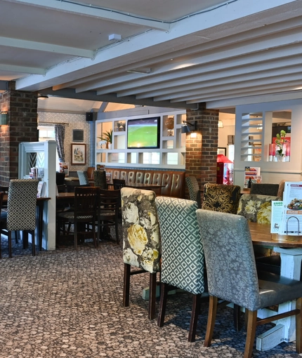 Interior dining area of a pub with a TV.