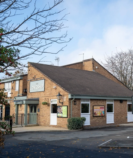 The exterior facade, signage, and car park of The Longship in Hebburn.
