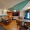 Interior dining area of a pub with a TV and a dartboard.