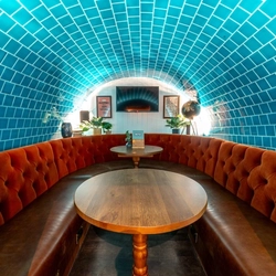 The interior tiled arched tunnel restaurant seating area with TV at The New Explorer.