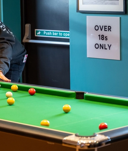 The interior games area with a man playing pool at the Hem Heath.