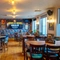 The interior restaurant seating area at the Counting House in Dumbarton, with brightly coloured wallpaper, and a TV on the wall.