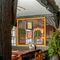 An interior restaurant seating area at The White Hart, with wooden beams, and potted plants hanging on the wall.