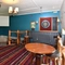 Interior dining area of a pub with a dartboard and a pull down projector screen.