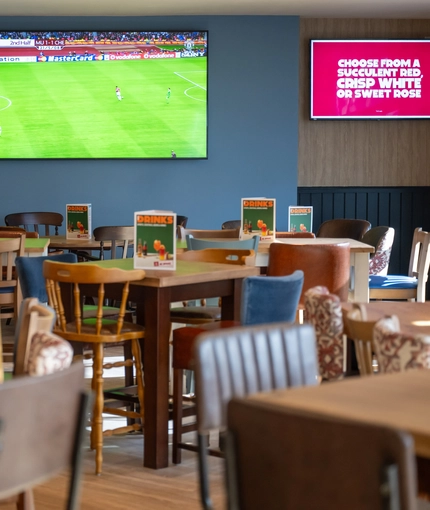 The interior restaurant and seating area with TV at The Woodlands.