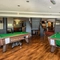 Interior dining area of a pub with two pool tables.