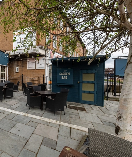 Exterior beer garden of a pub with a seating area.