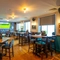 The interior restaurant seating area at the Counting House, with brightly coloured wallpaper, and a TV on the wall.