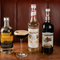 a few bottles and a cocktail sitting on a wooden table of a pub