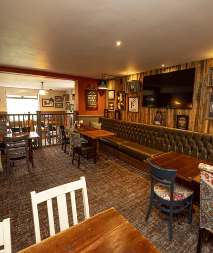 Interior dining area of a pub with a TV.