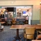 Interior dining area of a pub with a few TVs and a claw machine.