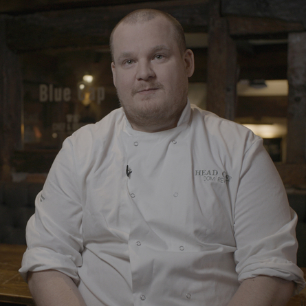 A portrait image of Dom the Head Chef within the interior of The Blue Cap.