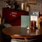 A close up of the interior restaurant table showing a display that consists of menus, salt and pepper shakers, candles and vases with decorative flowers at the Three Jolly Butchers.