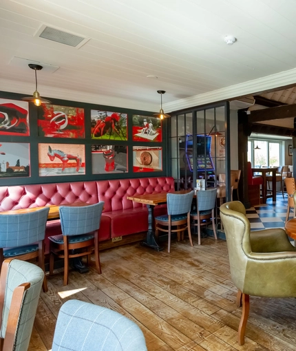 Interior dining area of a pub with a gambling machine.