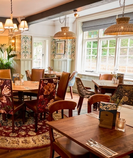 The interior restaurant and seating area with lit fireplace at the Queens Head.